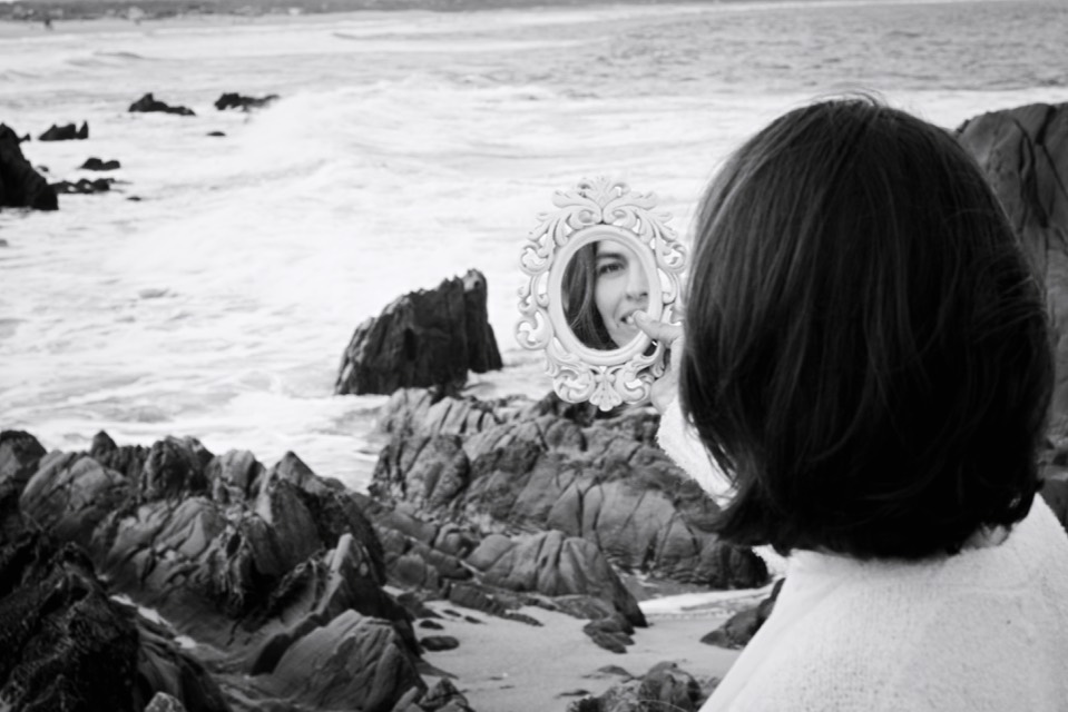 Caroluz frente al mar con un espejo